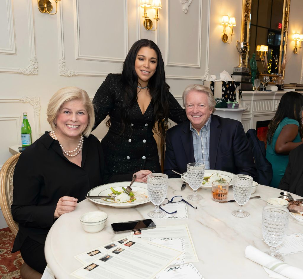 Erika Baez-Grimes exchanging a look with a fellow CEO at a private dinner
